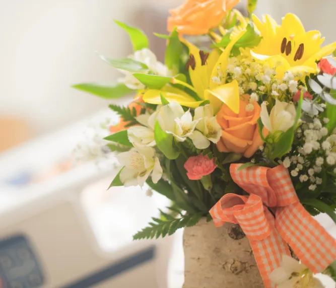 Bright yellow lilies and orange roses hospital get well flower arrangement